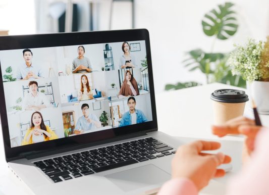 young-asia-businesswoman-using-laptop-talk-colleague-about-plan-video-call-meeting-while-work-from-home-living-room-min